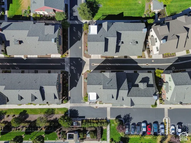 Aerial perspective showcasing asphalt roadways, paved sidewalks, and a parking area with multiple vehicles