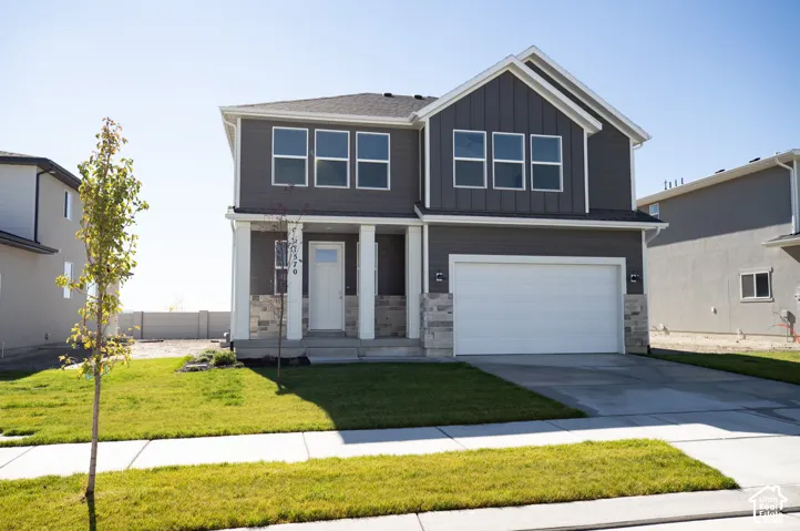 Spruce Elevation C with front yard landscaping installed and decorative concrete wall on rear boundary.