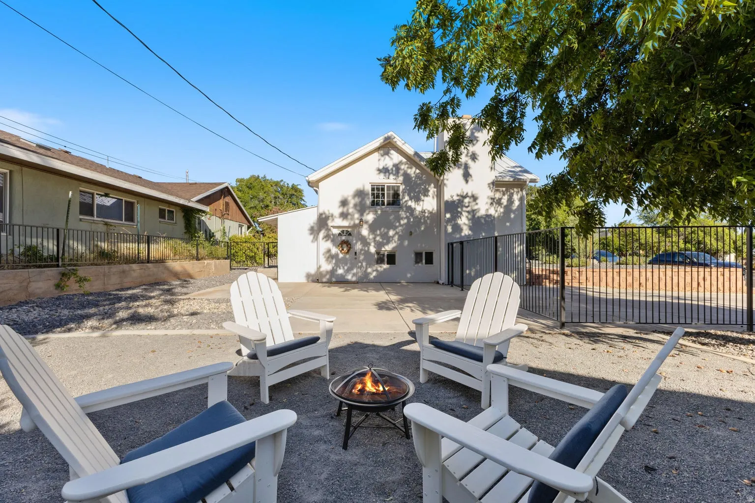 Rear exterior with a concrete patio, white stucco finish, and wrought iron fencing