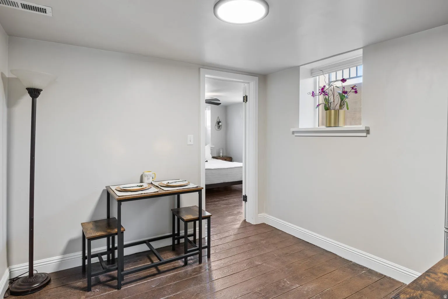 Wood-finish flooring with white baseboards and light gray walls