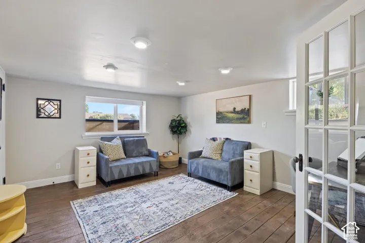 Wood-finish flooring with white baseboards, recessed lighting, and a white framed window