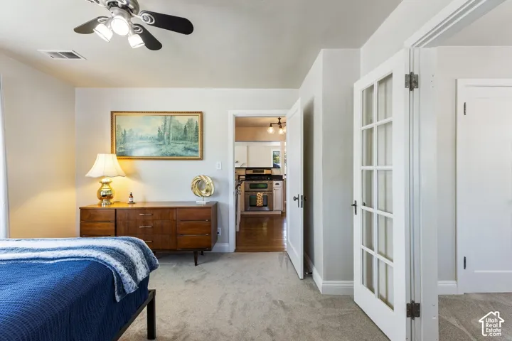 Recessed lighting, wood-finish flooring, and white cabinetry visible through the doorway