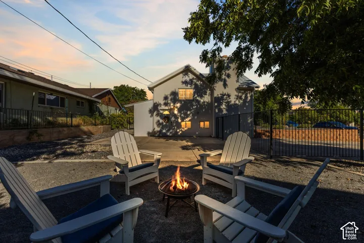 Outdoor fire pit area with gravel hardscaping and a black metal fence