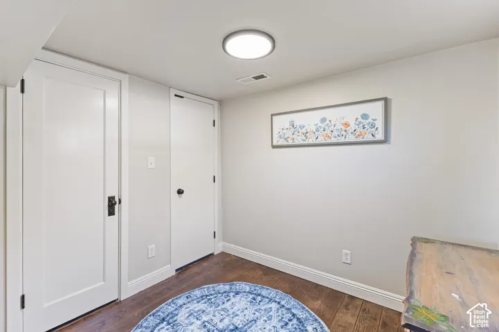 Wood-finish flooring, white trim, recessed lighting, and two panel doors
