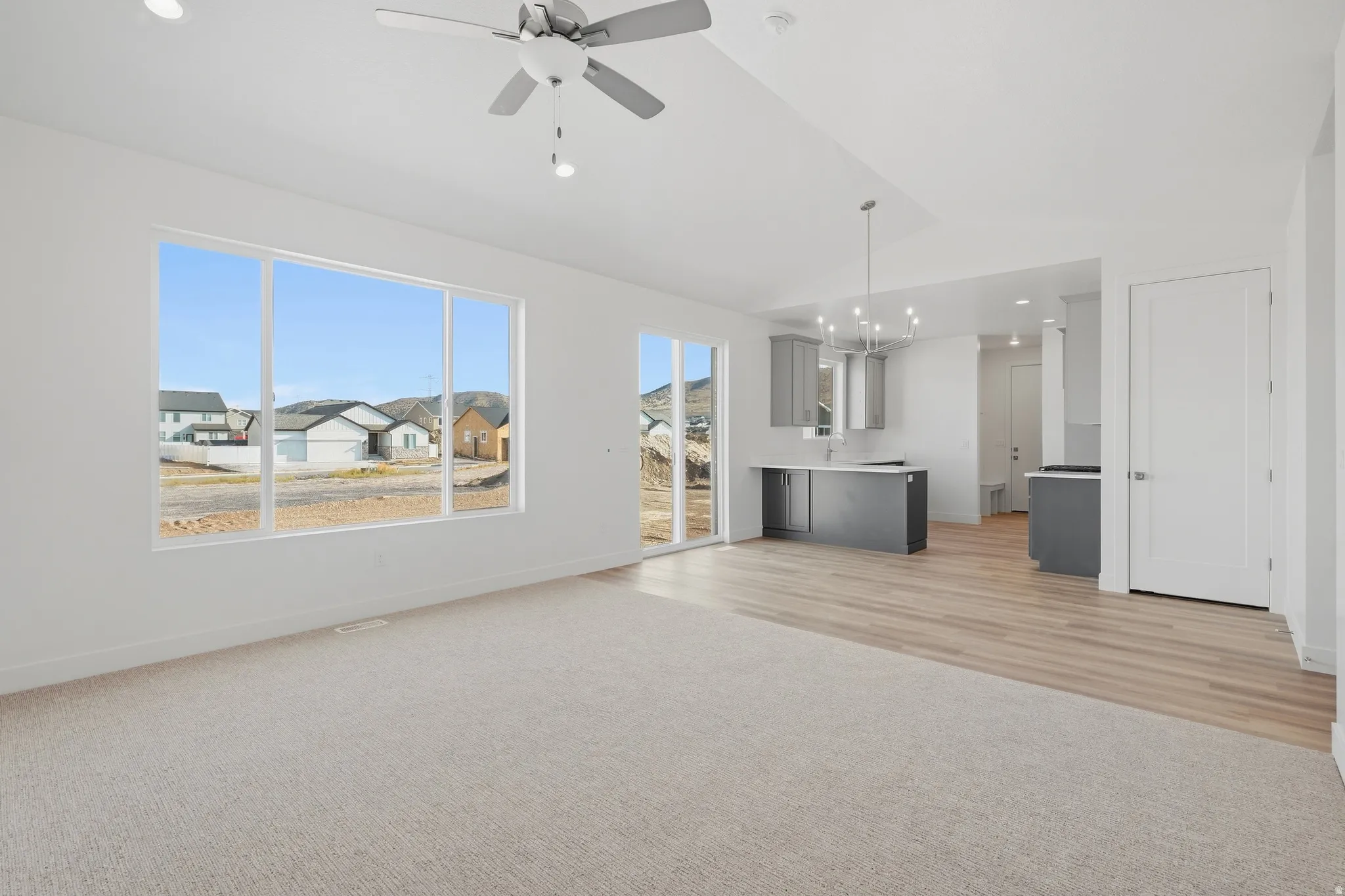 Carpeted living area with a large window, recessed lighting, and a ceiling fan