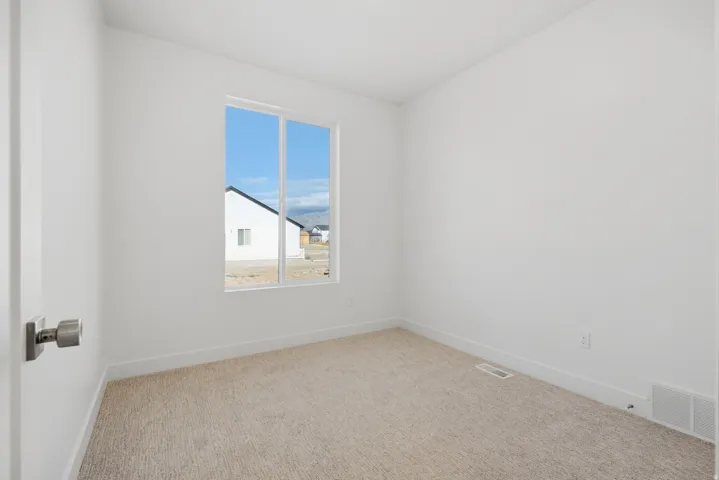 Recessed window with white trim, light-toned carpeting, and a neutral wall color