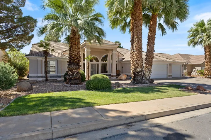 Stucco exterior with a tiled roof, arched entry, and a two-car garage