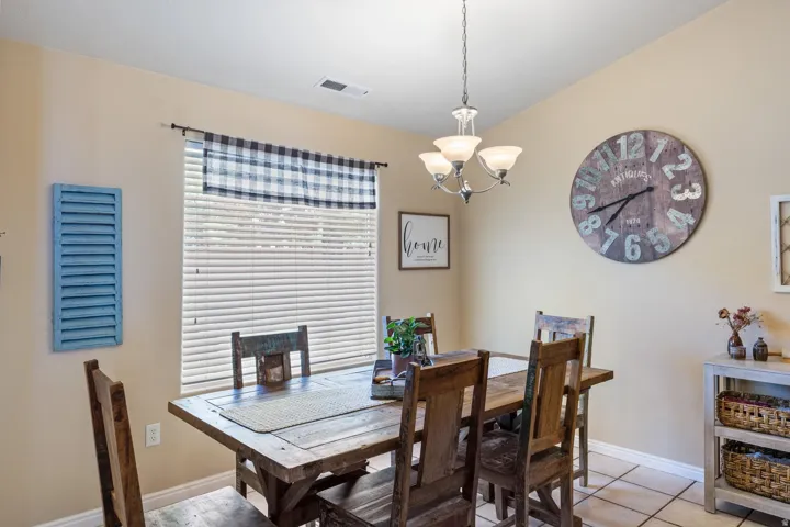 Recessed lighting, ceiling-mounted chandelier, window with blinds, and tile flooring