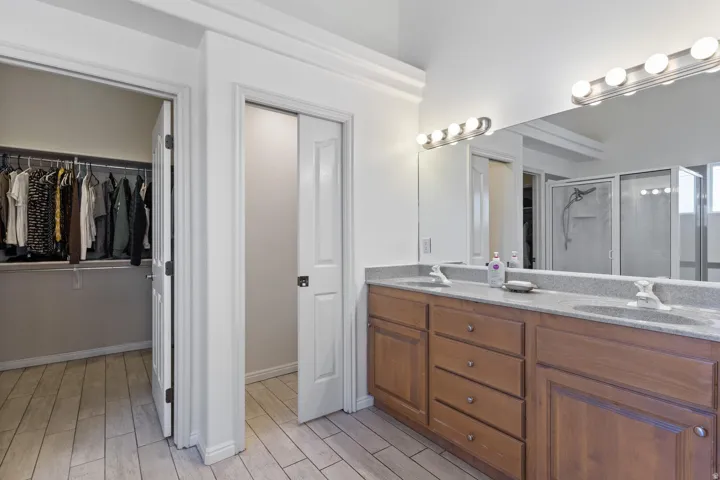 Double vanity with integrated sinks, full-width mirror, and overhead strip lighting