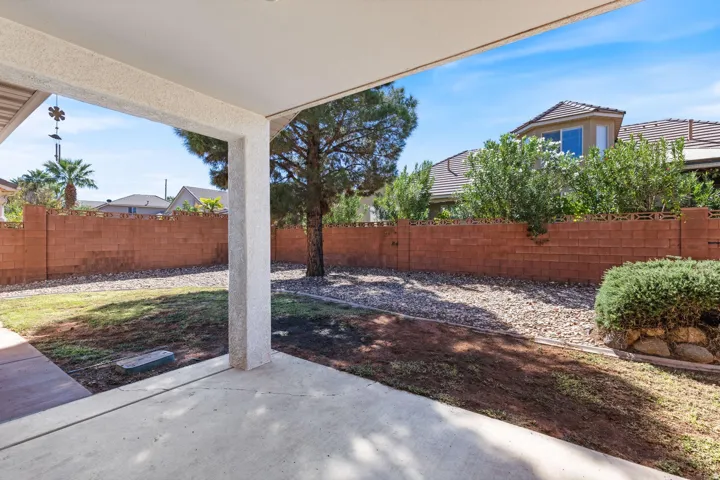 Expansive patio with a concrete surface, covered by a stucco ceiling and supported by a stucco column
