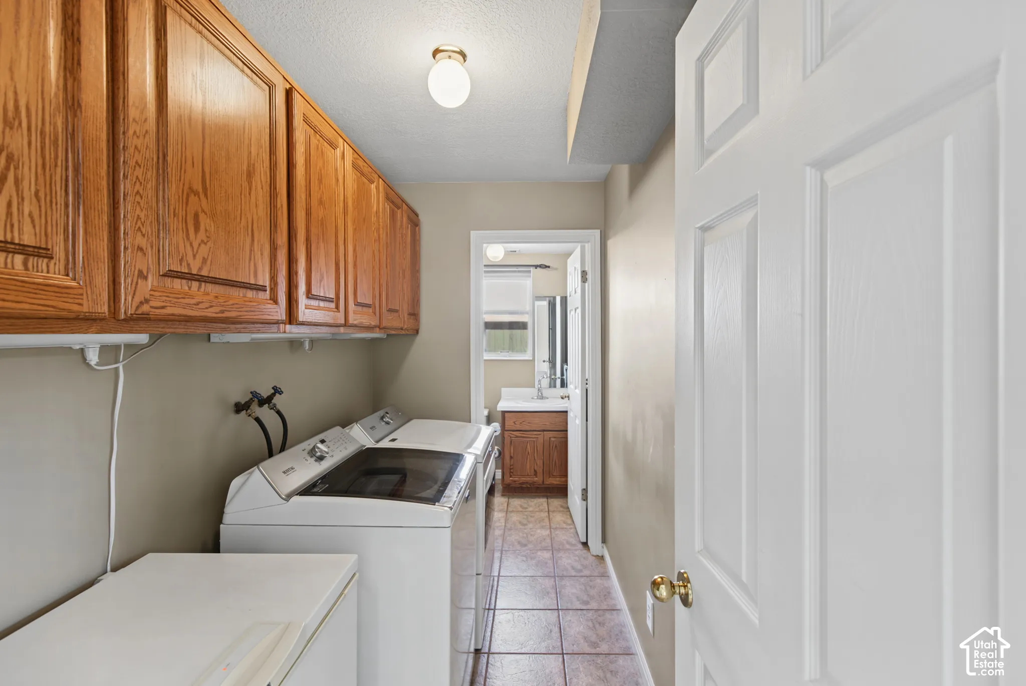 Hardwood-finish cabinetry, neutral wall paint, and tile flooring