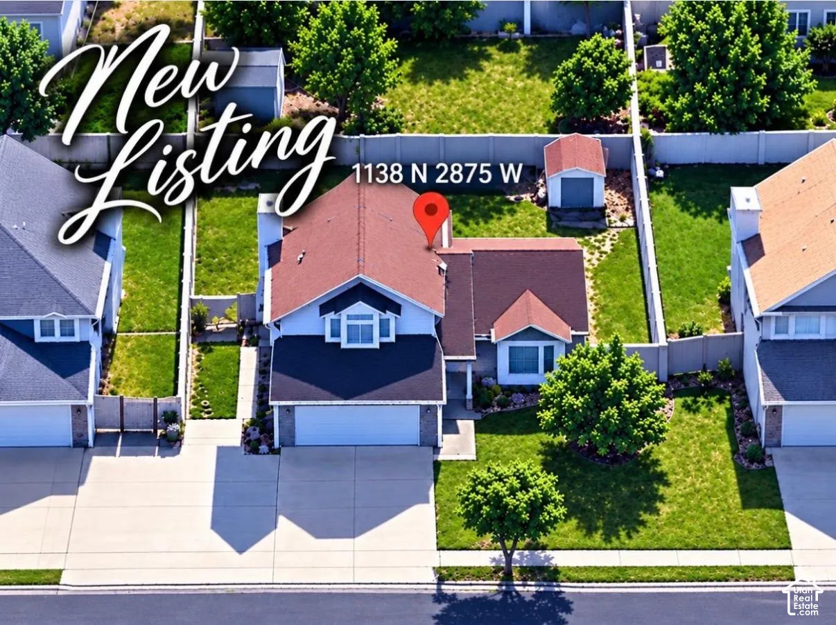 Two-story residence featuring a two-car garage, fenced backyard, and a detached storage shed