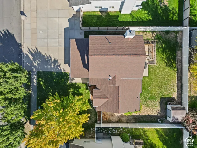 Property with a brown shingle roof, a light-colored exterior, an attached patio, a concrete driveway, and a white fence