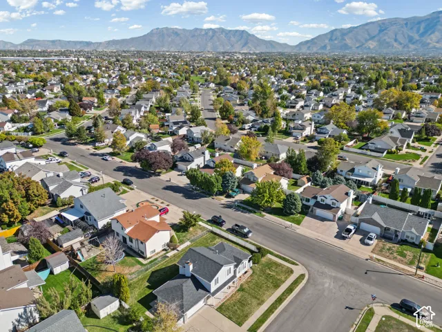 Residential neighborhood with established streets and mature trees, set against a mountain backdrop