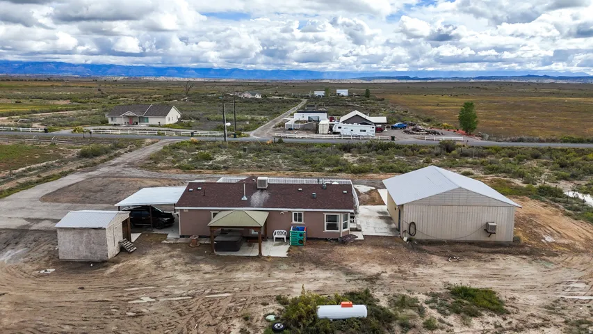 Expansive property featuring a detached outbuilding, separate storage shed, covered outdoor structure, and a covered parking area