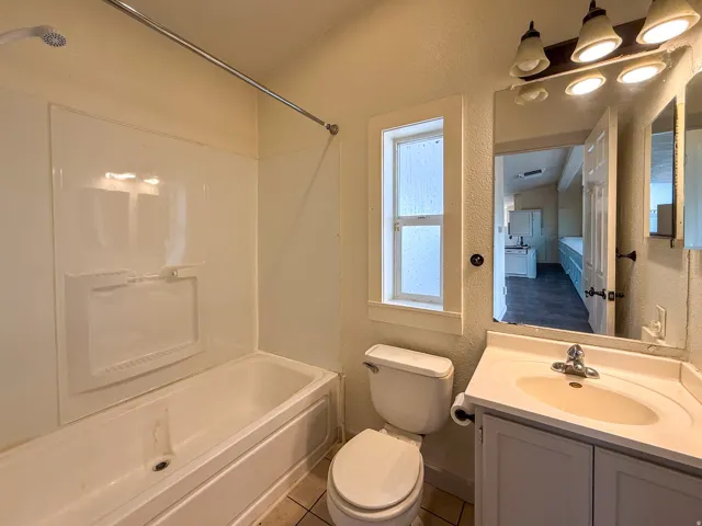 Bathroom featuring a tub/shower combination, vanity with integrated sink, and an overhead light fixture