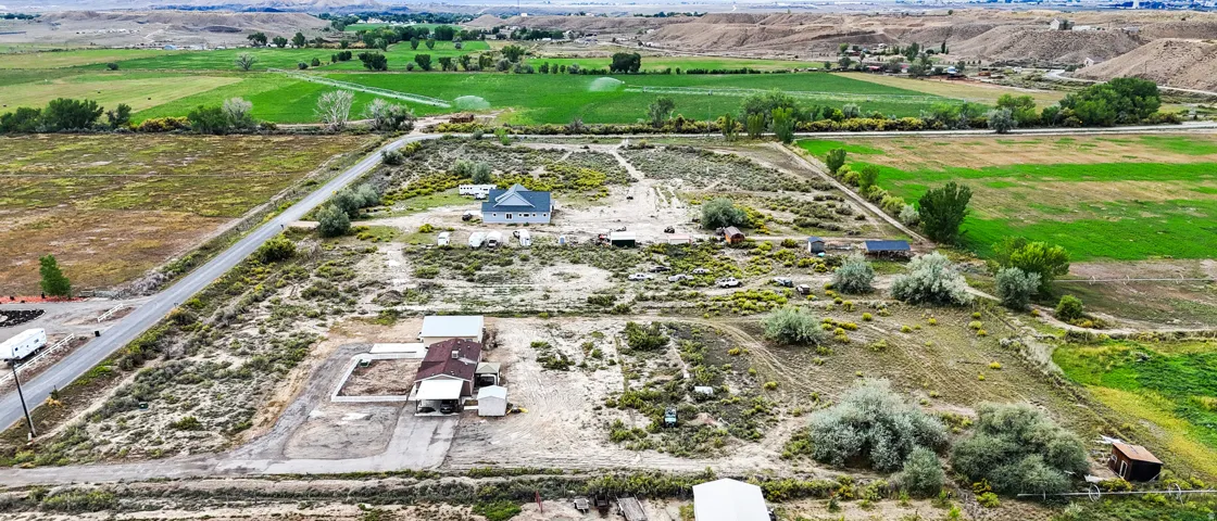 Two residential structures, an asphalt road, and expansive open land