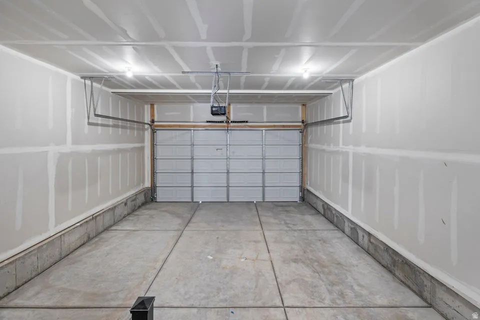 Concrete flooring, overhead garage door, automatic garage door opener, overhead lighting