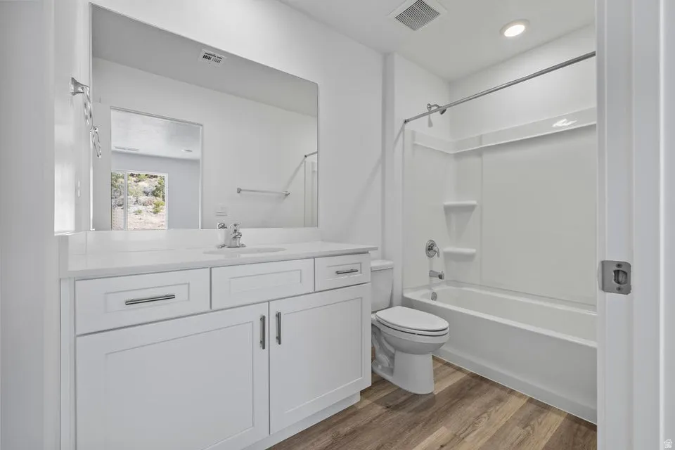 White vanity with shaker-style cabinetry, a white countertop, and a large wall-mounted mirror