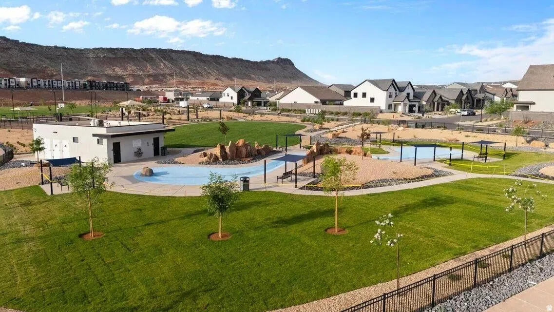 Community park featuring a splash pad, manicured green spaces, and a modern amenity building