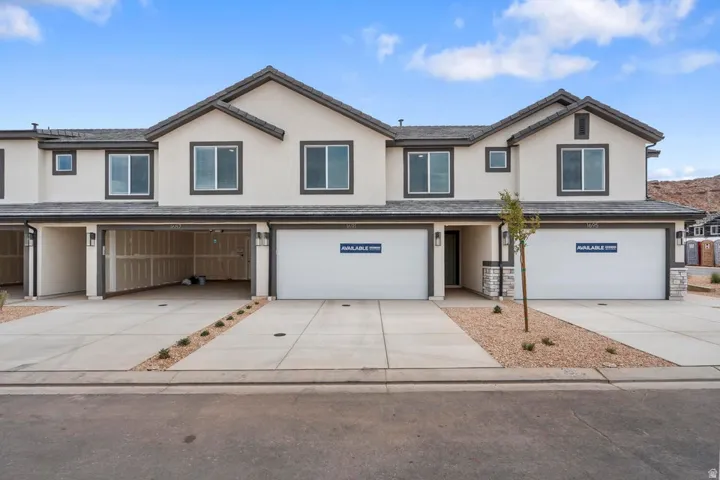 Contemporary townhome exterior featuring stucco siding and dark trim