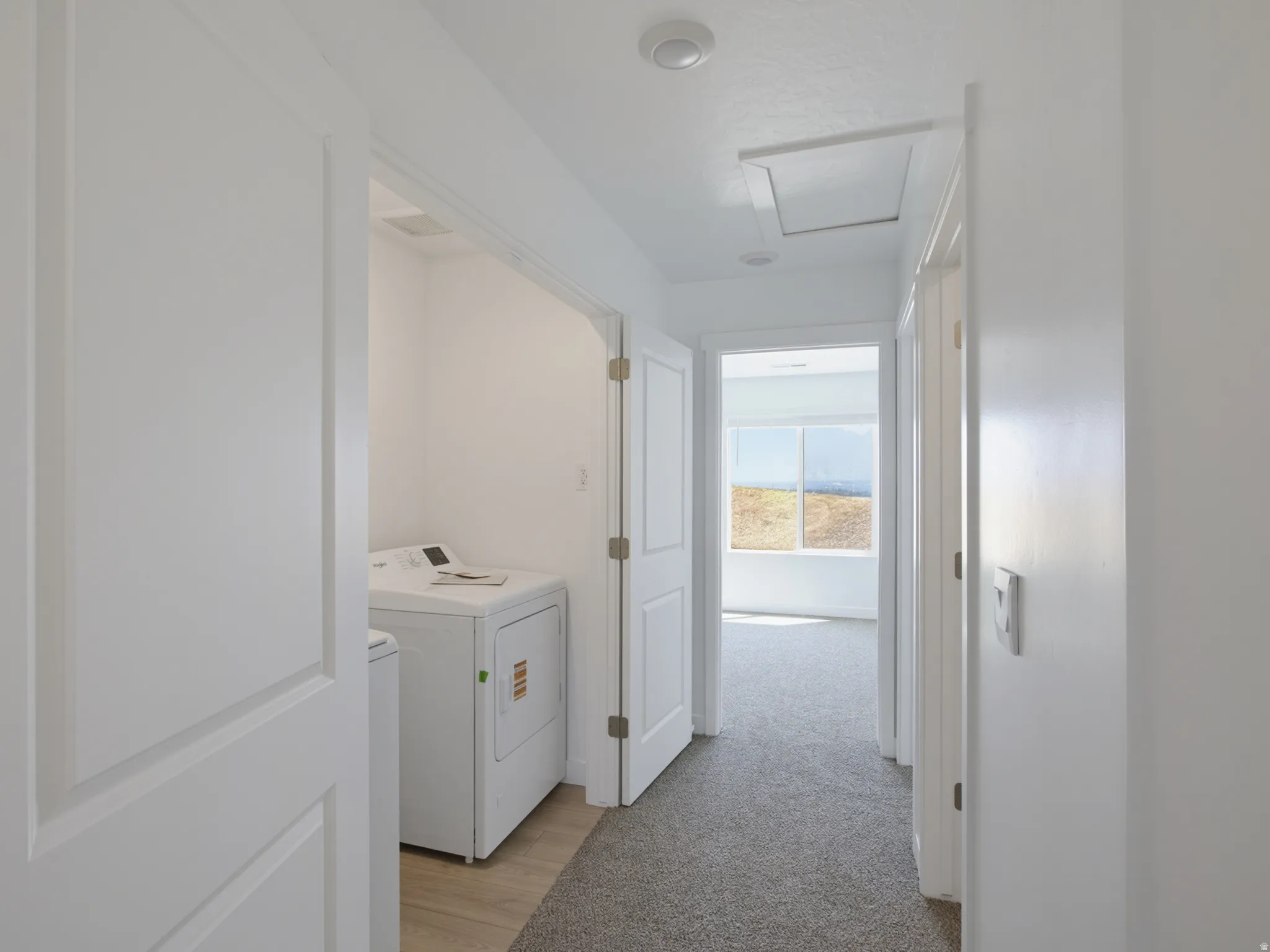 Laundry area with wood-finish flooring