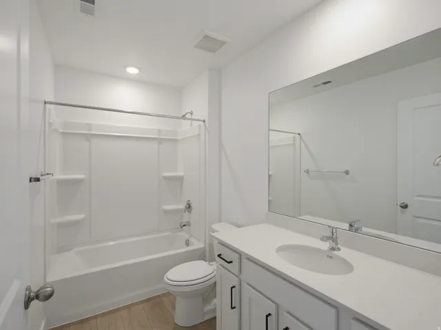 White vanity with matte black hardware, integrated sink, and stone-finish countertop