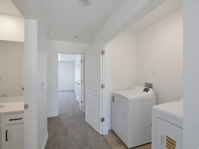 Hallway with gray carpeting, recessed ceiling lighting, and white paneled doors
