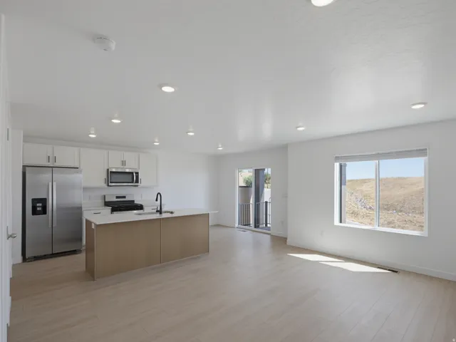 Open-concept living space with recessed lighting, wood-finish flooring, and a sliding glass door