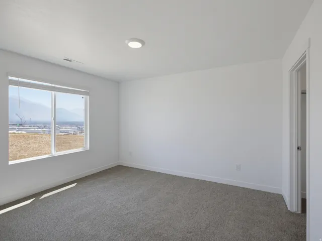 Carpeted flooring, white walls, and a window with mountain scenery