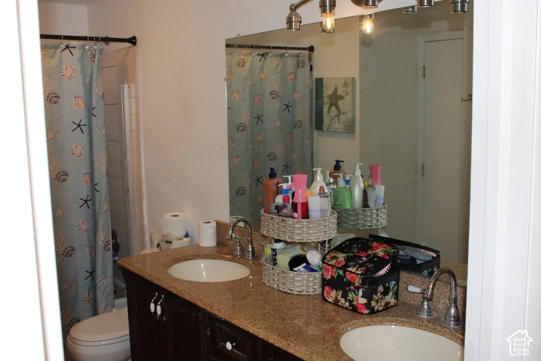 Dual vanity with undermount sinks, granite-finish countertop, and dark wood-finish cabinetry