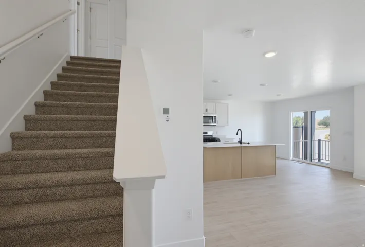 Open-concept living area with wood-finish flooring, recessed lighting, and a modern kitchen