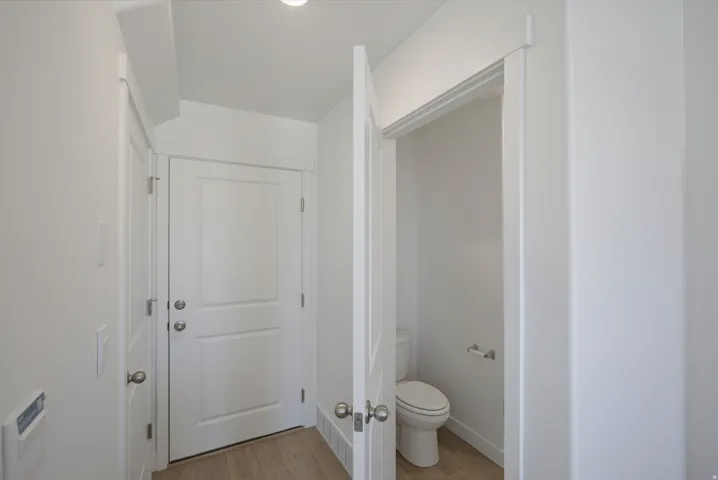 White paneled interior doors, wood-finish flooring, and crisp white wall finishes