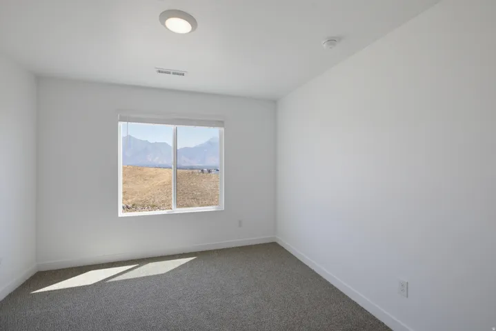 Neutral wall paint, recessed lighting, window offering mountain scenery, and carpeted flooring