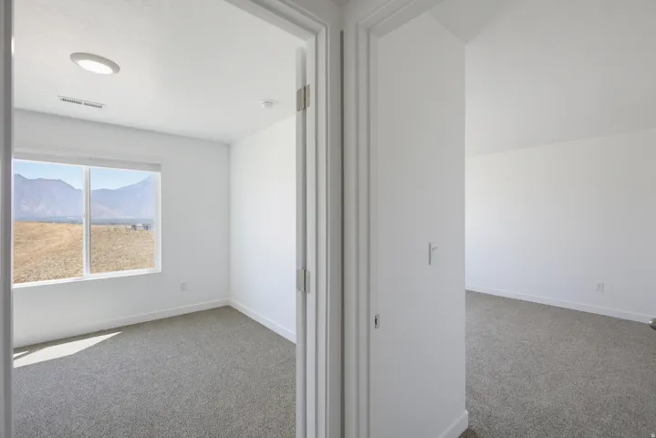 Window with exterior scenery, overhead lighting, and carpeted flooring