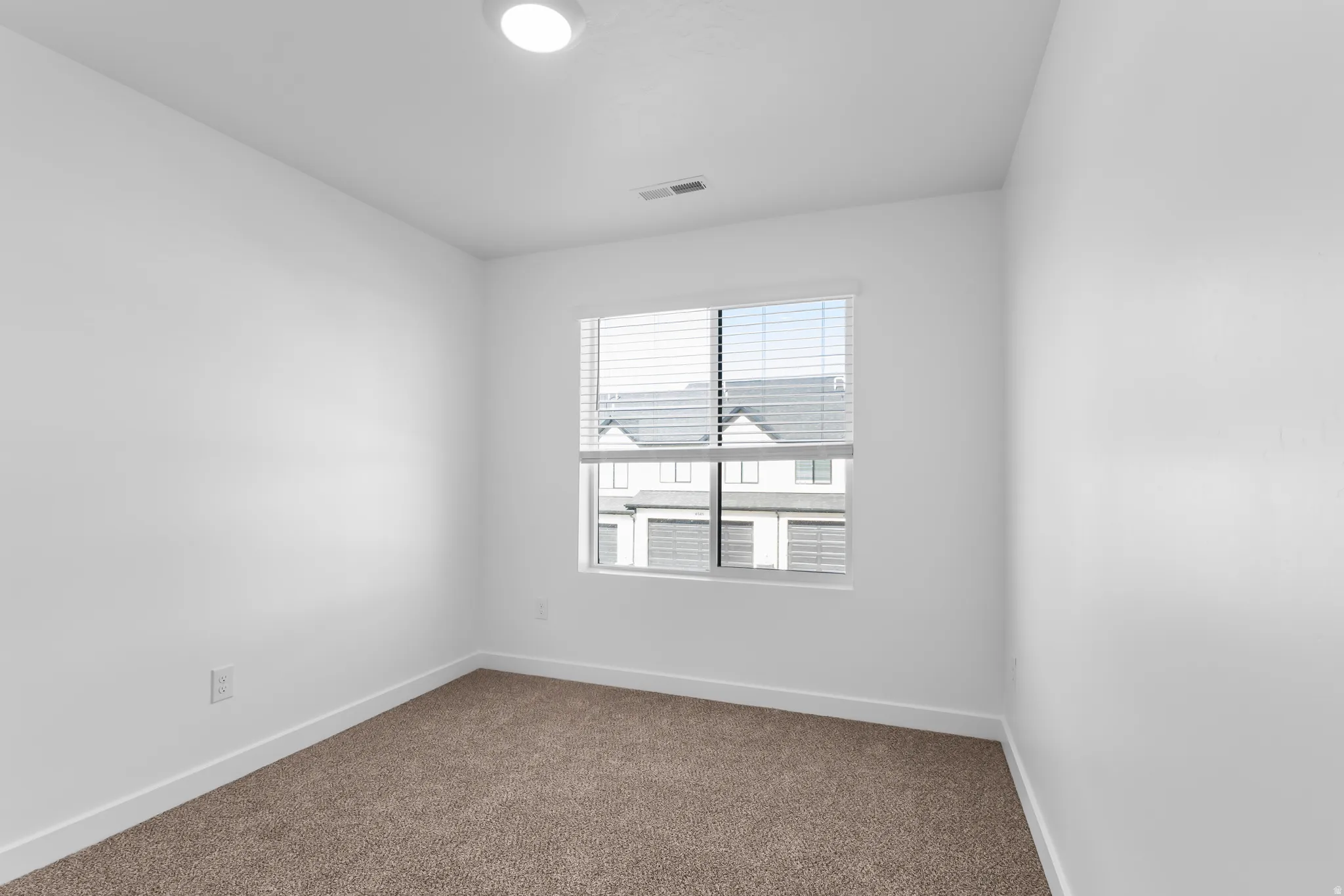 Recessed ceiling lighting, white walls, window with blinds, baseboard trim, and carpeted flooring
