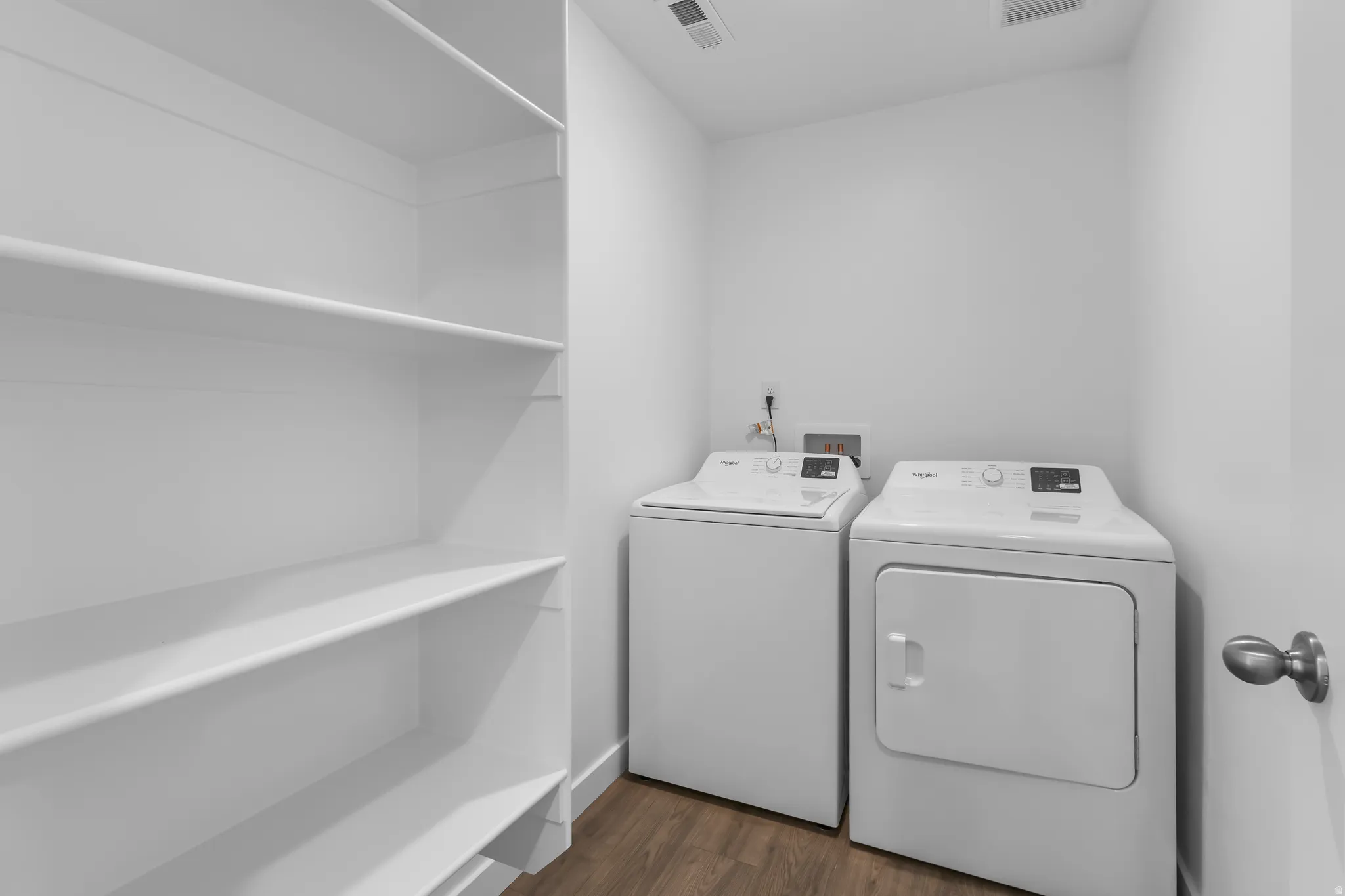 White built-in shelving, wood-finish flooring, and white walls