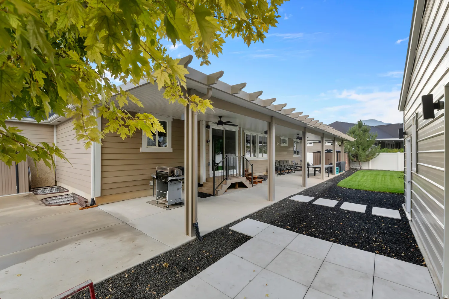 Expansive covered 70 foot long patio with overhead fan, concrete patio, and pergola elements