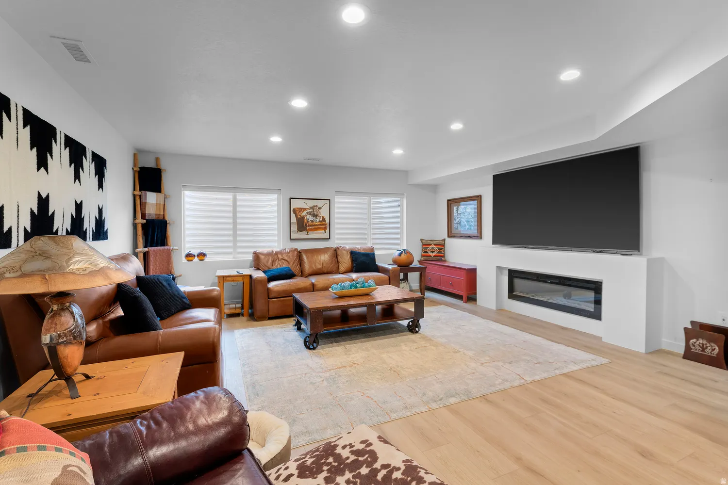 Recessed lighting illuminates the living area with wood-finish flooring
