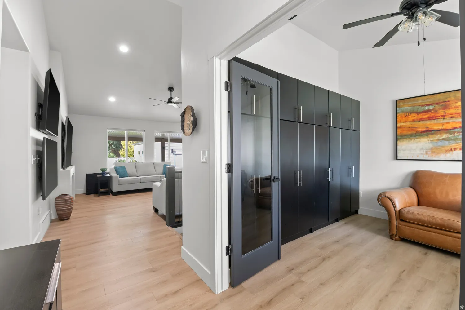 Wood-finish flooring throughout, recessed lighting, and a modern ceiling fan