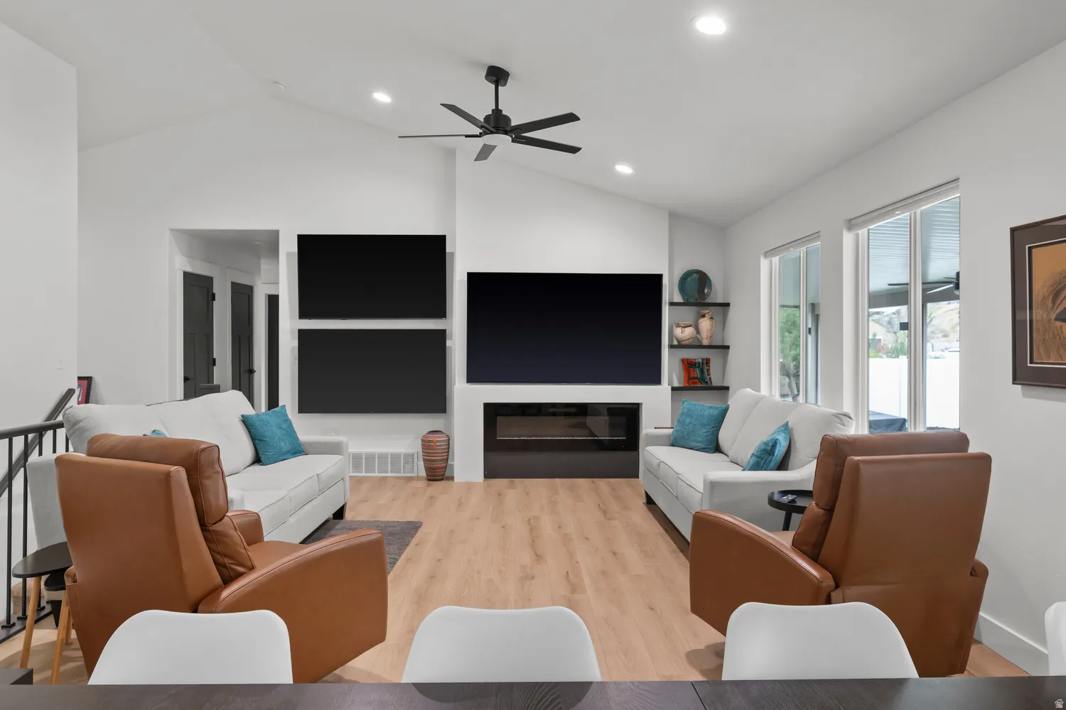Vaulted ceiling with recessed lighting and ceiling fan, wood-finish flooring, and a built-in fireplace