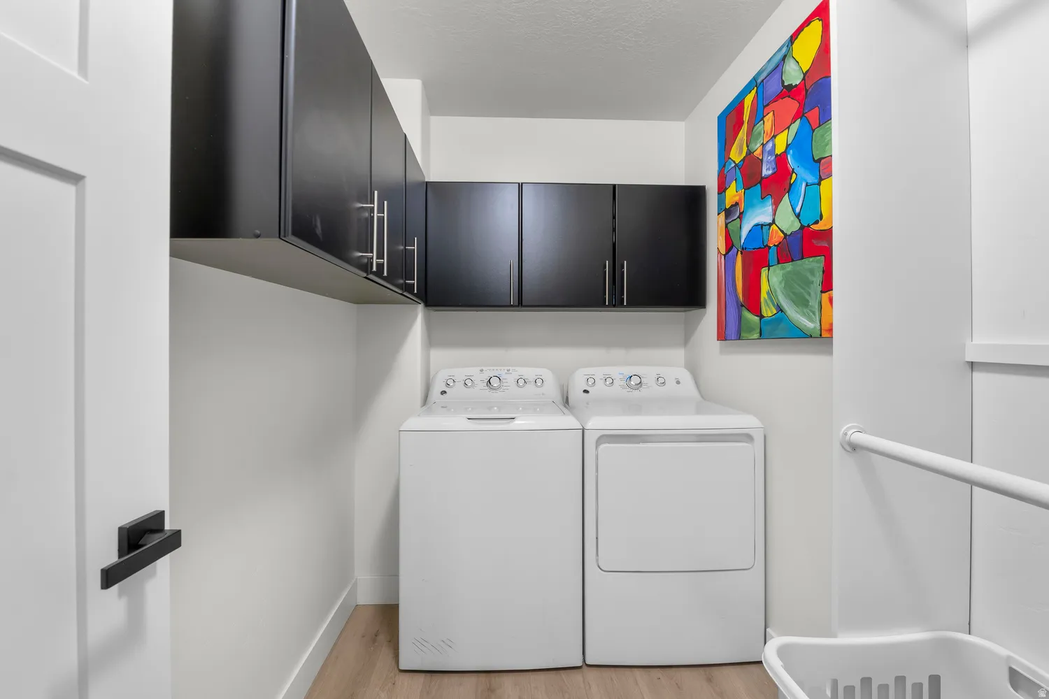 Built-in black cabinetry with brushed nickel hardware and wood-finish flooring