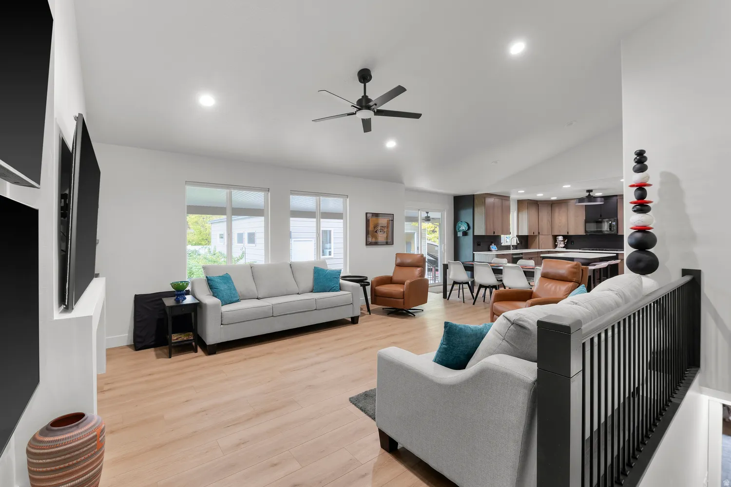 Open-concept living area with vaulted ceiling, wood-finish flooring, recessed lighting, and a modern ceiling fan