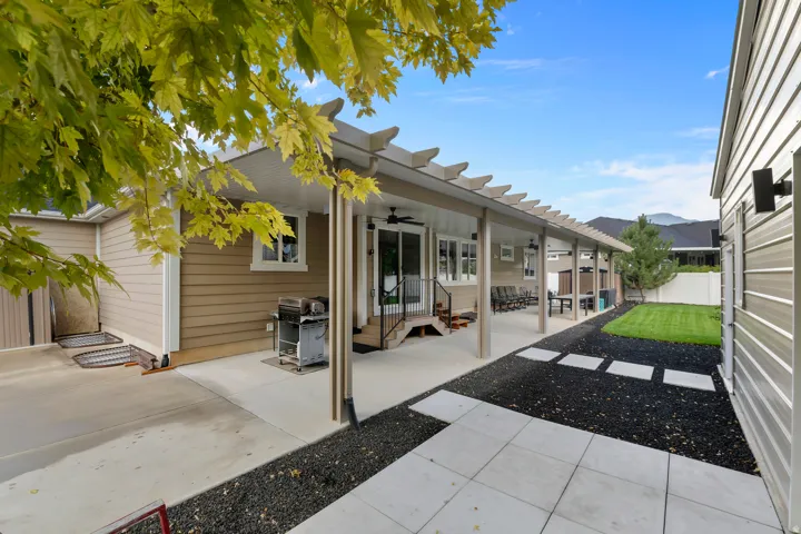 Expansive covered 70 foot long patio with overhead fan, concrete patio, and pergola elements