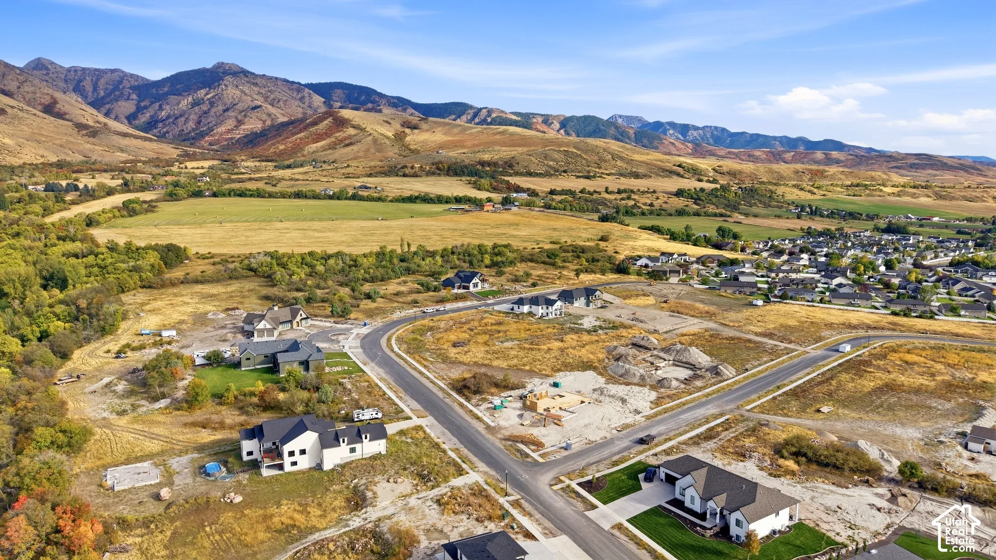 Mountainous terrain backdrop with expansive undeveloped land, established residential areas, and new construction development