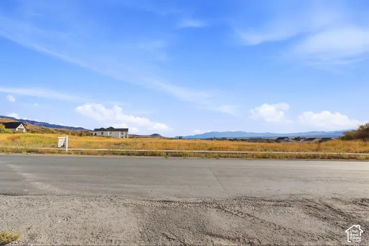 Expansive lot featuring a paved road frontage and distant mountain range