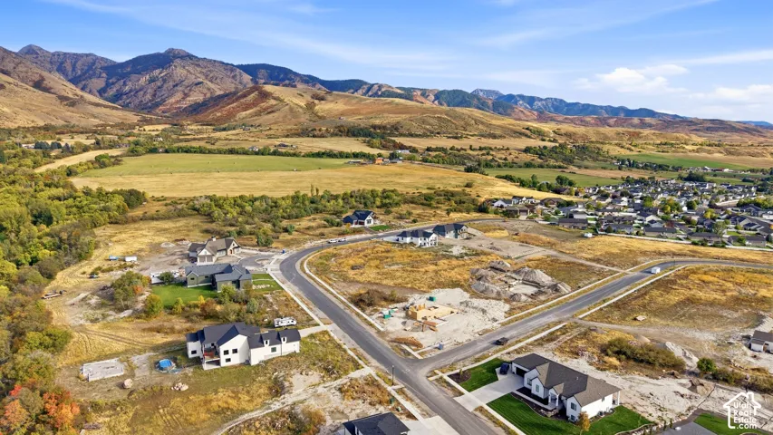 Mountainous terrain backdrop with expansive undeveloped land, established residential areas, and new construction development