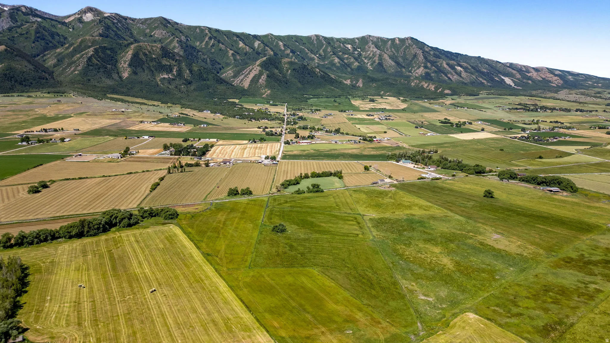 Expansive agricultural land featuring cultivated fields and green pastures