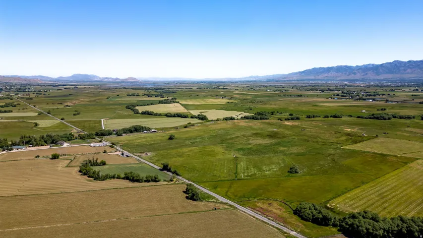 Expansive agricultural land featuring varied crop fields and distant mountainous terrain
