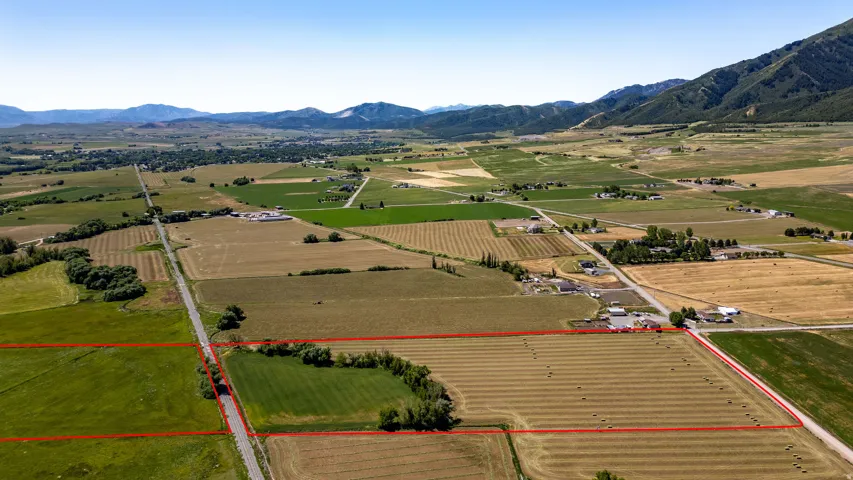 Expansive rural landscape featuring agricultural fields and distant mountains